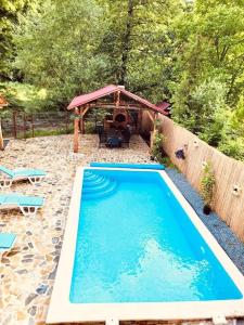 a swimming pool in a backyard with a gazebo at River House Transylvania in Frăsinet