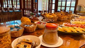 un tavolo con un mucchio di cibo sopra di Village de France Araucárias a Campos do Jordão