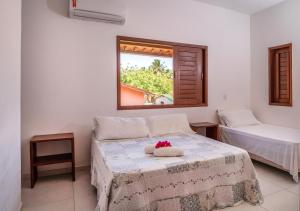 a bedroom with a bed with a window and a bed sidx sidx sidx at Zion Suítes in Jericoacoara