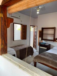 a bedroom with two beds and a television in it at Estalagem Sol de Boipeba in Ilha de Boipeba