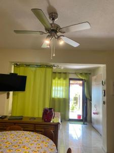 - un ventilateur de plafond dans le salon avec un rideau jaune dans l'établissement Panorama Drenia, à Ouranoupoli