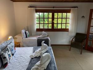 uma sala de estar com dois cisnes nas camas em Village de France Araucárias em Campos do Jordão