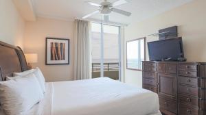 a bedroom with a bed with a television and a dresser at Ocean Club 1606 in Biloxi