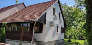 Casa blanca con techo marrón en Borcsa Pihenőház, en Mezőkövesd