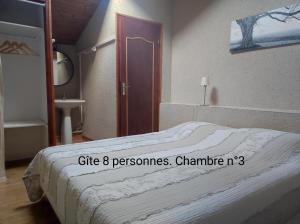 Un dormitorio con una cama y una puerta con un cartel. en 2 Gites proche Puy du fou en Mauléon