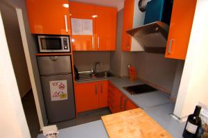 托羅埃利亞－德蒙特格里的住宿－Mare Nostrum 2D 324，小厨房配有橙色橱柜和冰箱