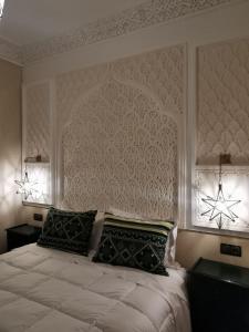 um quarto com uma grande cama branca e 2 almofadas em Riad Bijoux em Marraquexe
