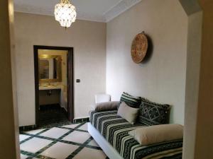 uma sala de estar com um sofá e um espelho em Riad Bijoux em Marraquexe