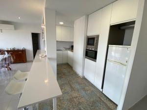 uma cozinha com armários brancos e um balcão branco em Mare Nostrum 3D 541 em Torroella de Montgrí