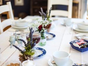 a table with plates and cups and flowers on it at Birch House Bed & Breakfast in Weymouth