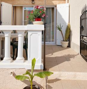 a porch with a white table and a plant at Maisonnette proche Mer Terrasse Parking Climatisée in Villeneuve-Loubet