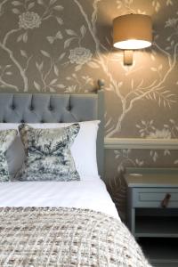 a bedroom with a bed and a lamp and a nightstand at The Broadoak in Ashton under Lyne