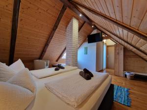 two beds in a room with wooden ceilings at Zum Alten Schulhaus in Burg