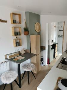 a small kitchen with a table and two stools at Le cabanon in Méneslies