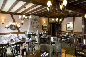 un restaurante con mesas y sillas en una habitación en The Broadoak en Ashton under Lyne
