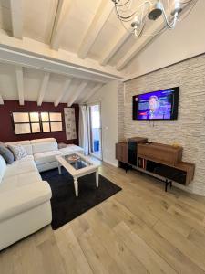 een woonkamer met een witte bank en een tv bij Splendid Lake in Desenzano del Garda