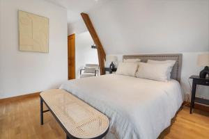 une chambre avec un grand lit blanc et une chaise dans l'établissement Home Suite Home avec Piscine centre Deauville 5BR/10P, à Deauville 42 autres photos