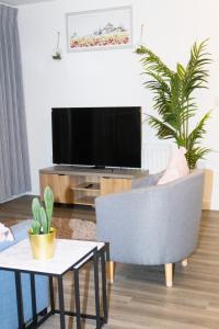 een woonkamer met een tv en een stoel en een tafel bij Luxurious MK Apartment-Campbell Park in Milton Keynes