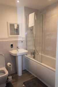 a bathroom with a sink and a shower and a toilet at Luxurious MK Apartment-Campbell Park in Milton Keynes