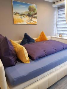 Bett mit bunten Kissen auf einem Zimmer in der Unterkunft Apartment Luxus "Akzente-Art Minden" in Minden
