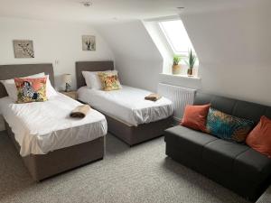 a room with two beds and a couch and a window at The Gather Inn in Brighton & Hove