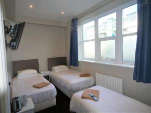 Habitación de hotel con 2 camas y ventana en The Gather Inn, en Brighton & Hove