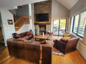 a living room with leather furniture and a fireplace at White Mountain Vista! in Lincoln