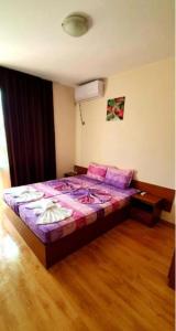 プリモルスコにあるGuest House Nataliのベッドルーム1室(紫のシーツが敷かれた大型ベッド1台付)