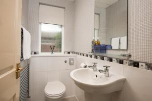 een badkamer met een wastafel, een toilet en een spiegel bij Morwick House B&B in Warkworth