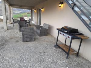 einen Grill auf einer Terrasse mit Stühlen und einem Tisch in der Unterkunft bien-être de l'Aveyron in Aguessac