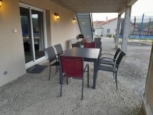 una mesa negra y sillas en un patio en bien-être de l'Aveyron, en Aguessac