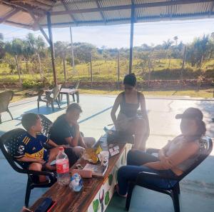 Un groupe de personnes assises autour d'une table de pique-nique dans l'établissement Glamping Amazonas, à Leticia