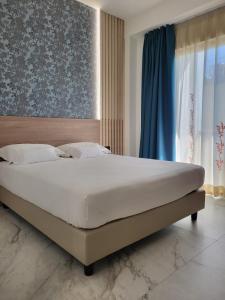 - une chambre avec un grand lit et une fenêtre dans l'établissement Hotel Maiuri Pompei, à Pompéi