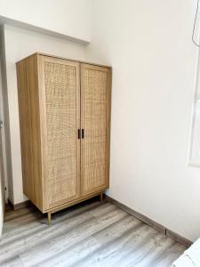 a wicker cabinet in a corner of a room at Nordic Nest in Givet