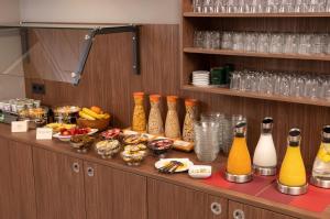 ein Buffet mit Flaschen Saft und Speisen in der Unterkunft Best Western Comfort Business Hotel Düsseldorf-Neuss in Neuss