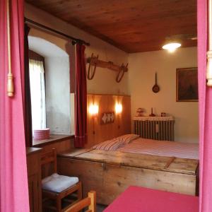 ein Schlafzimmer mit einem Bett mit einem Holzrahmen in der Unterkunft Al Piz Monolocale in Colle Santa Lucia