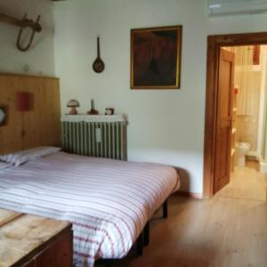 a bedroom with a bed with a striped blanket at Al Piz Monolocale in Colle Santa Lucia