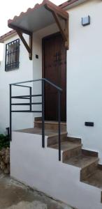eine Treppe, die zu einem Haus mit einer Holztür führt in der Unterkunft Studio with furnished terrace at Riogordo in Ríogordo