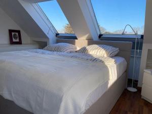 a bedroom with a white bed with a large window at Studio - a79311 in Loxstedt