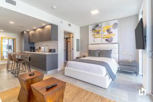 a bedroom with a white bed and a kitchen at Downtown Miami Condos by Lua Host in Miami