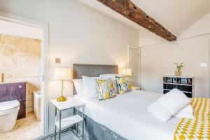 - une chambre blanche avec un lit et un miroir dans l'établissement Loft Piccadilly Circus Apartment, à Londres