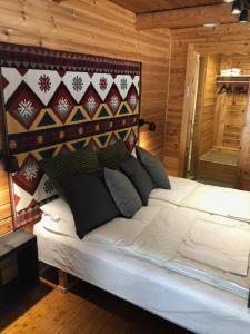 a large white bed in a room with wooden walls at Kätkä Lake Lodge in Tervola