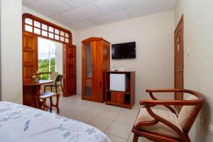 a bedroom with a bed and a tv and a table at Hotel Villa Laguna in Puerto Ayora