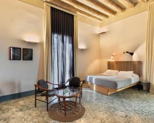 バーリにあるパラッツォ カロのベッドとテーブルが備わるホテルルームです。
