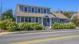 a blue house with flowers in front of a street at Walk to Beach and Town, Hot tub, Sleeps 8, Pet Friendly in Chatham +60 photos