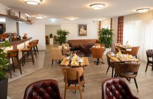 a restaurant with tables and chairs and a bar at Best Western Comfort Business Hotel Düsseldorf-Neuss in Neuss