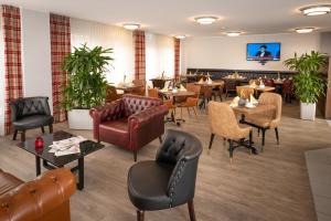 a restaurant with leather furniture and tables and chairs at Best Western Comfort Business Hotel Düsseldorf-Neuss in Neuss