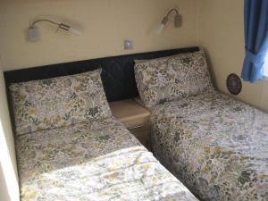 1 dormitorio con 2 camas y cabecero en Violet 28 Oakdene Forest Park, en Ferndown