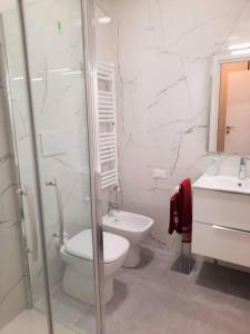 a white bathroom with a toilet and a sink at Appartamento incantevole Viareggio mare in Viareggio