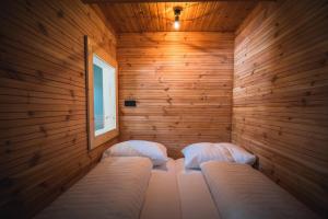 a sauna with two beds in a wooden wall at Tauernlust Outdoor & Relax in Mallnitz